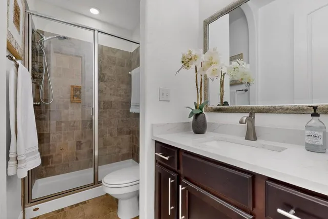 a bathroom with a sink a toilet and shower