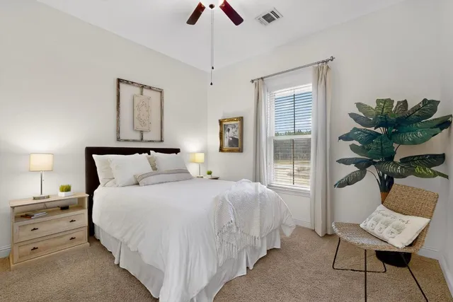 a bedroom with a bed and a potted plant