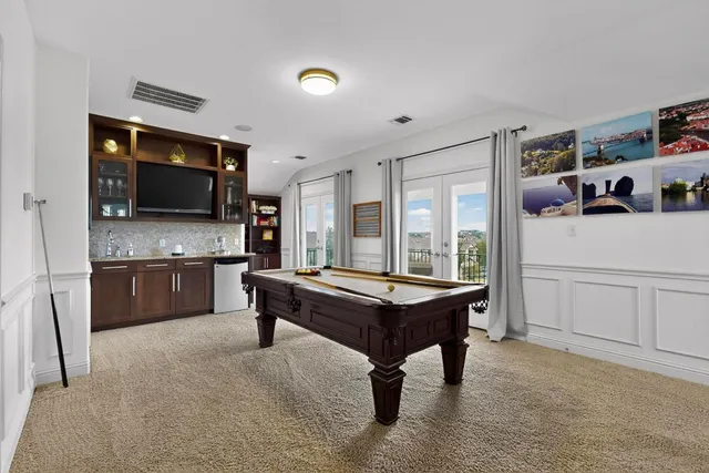 a room with kitchen island a flat screen tv and a refrigerator