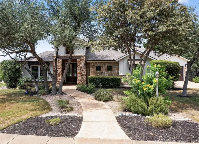 a view of a house with a tree in front of it