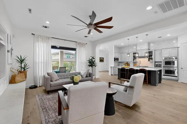 a living room with lots of kitchen furniture and a large window