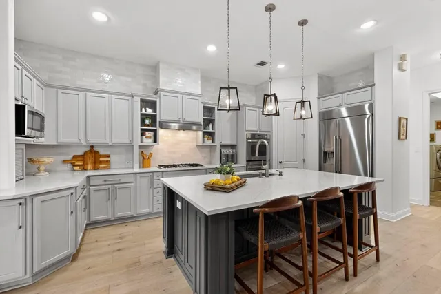 a kitchen with stainless steel appliances a white table and chairs