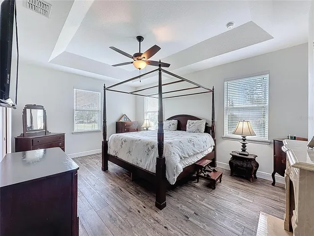 a bedroom with a bed and a flat tv screen on wall