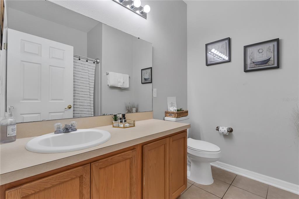 506 Kettering Road Davenport, FL 33897 - Photo 19 of 45 a bathroom with a granite countertop sink toilet and a mirror