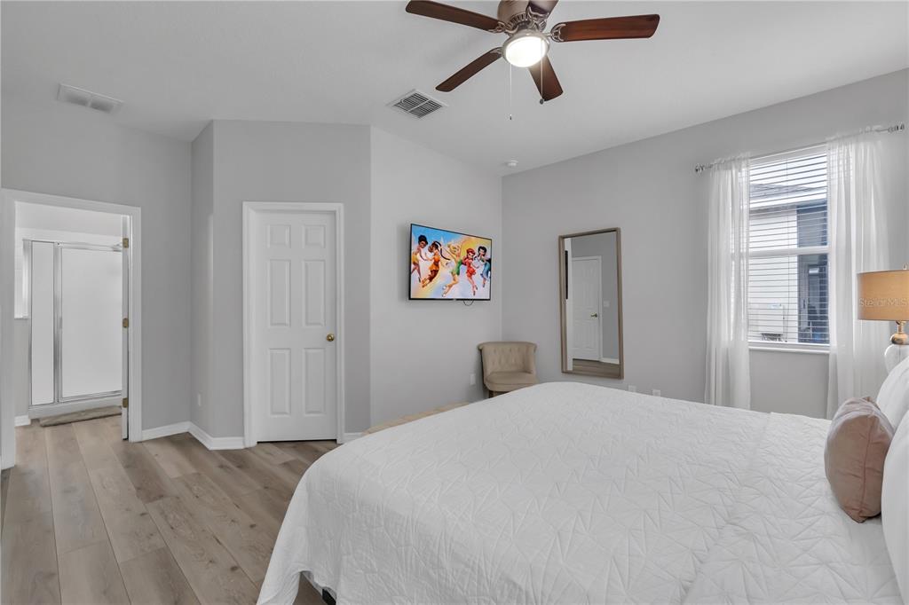 506 Kettering Road Davenport, FL 33897 - Photo 24 of 45 a bedroom with a large bed and a chandelier