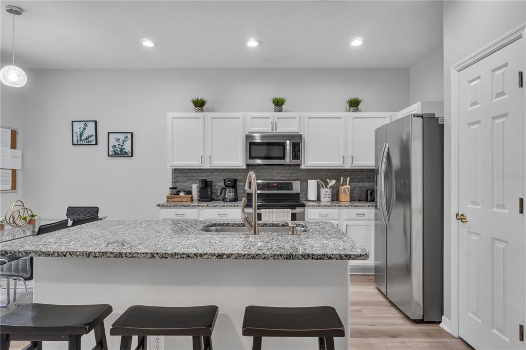 506 Kettering Road Davenport, FL 33897 - Photo 6 of 45 a kitchen with stainless steel appliances granite countertop a sink refrigerator and microwave