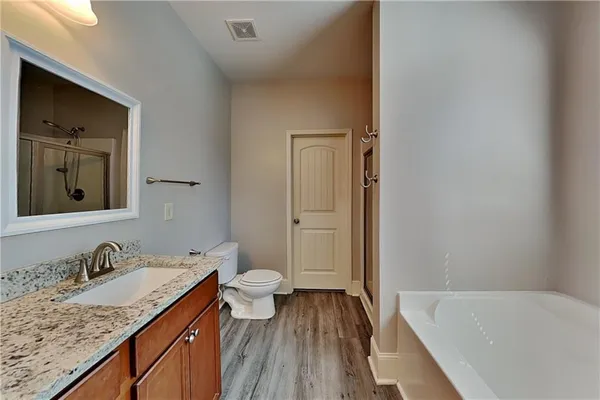 a bathroom with a granite countertop sink mirror vanity and toilet