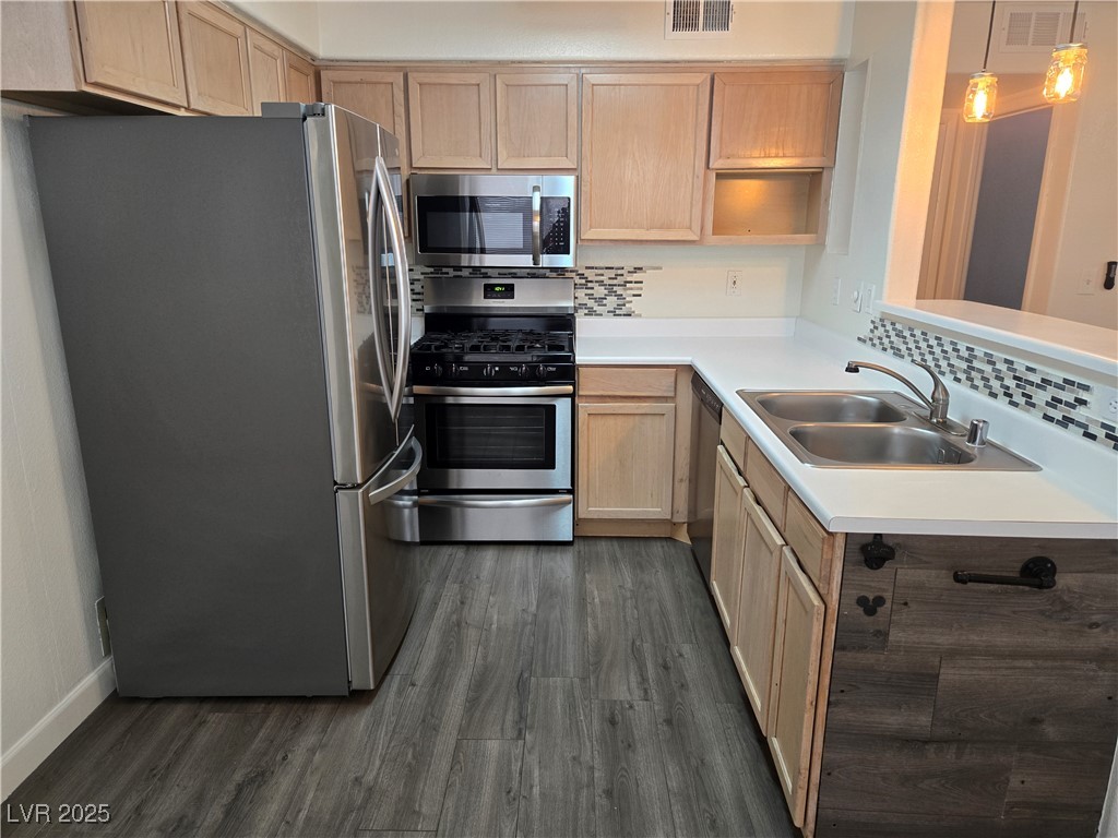 3168 Tarpon, Unit 103 Las Vegas, NV 89120 - Photo 5 of 23 Kitchen with appliances with stainless steel finishes, light countertops, backsplash, dark wood-style flooring, and open shelves
