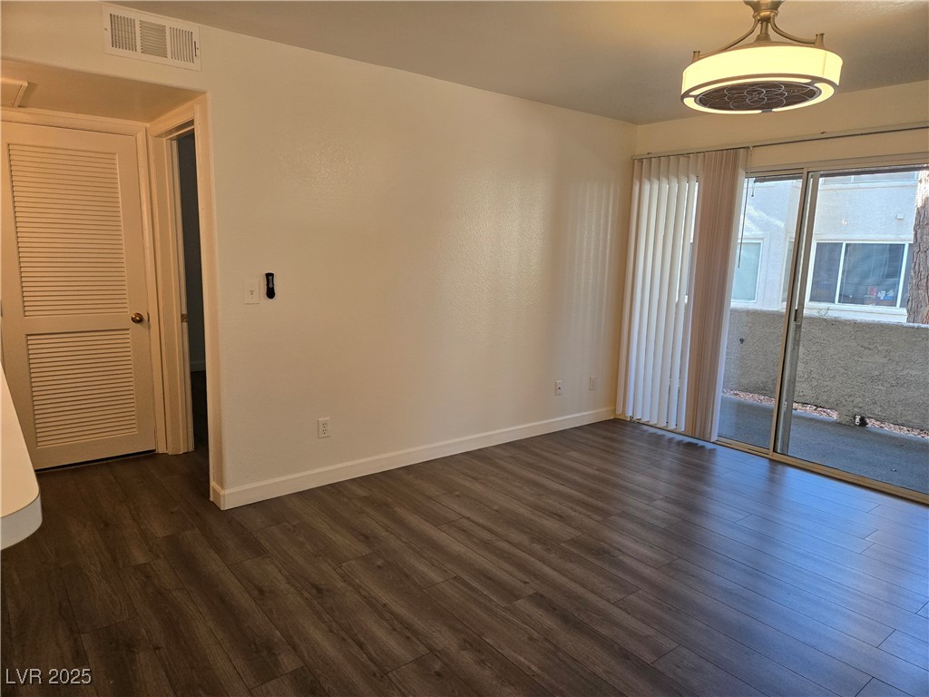 3168 Tarpon, Unit 103 Las Vegas, NV 89120 - Photo 8 of 23 Empty room with dark wood finished floors and baseboards
