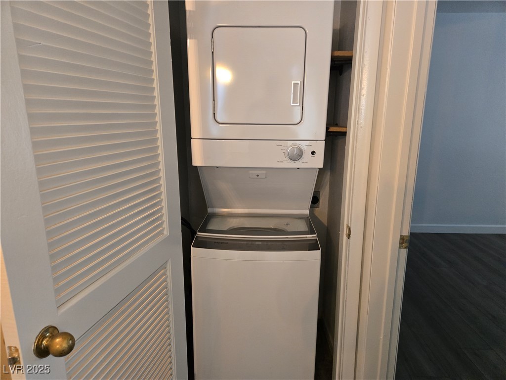 3168 Tarpon, Unit 103 Las Vegas, NV 89120 - Photo 10 of 23 Laundry room with stacked washer and clothes dryer and dark wood finished floors