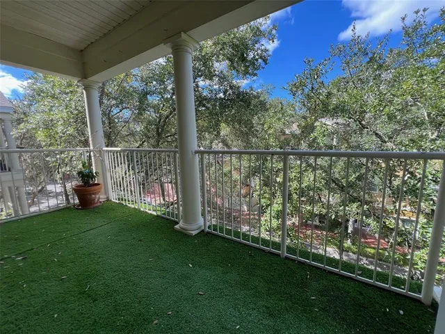 a view of balcony with floor to ceiling window next to a yard