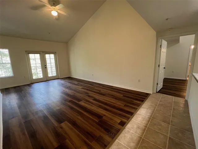 a view of empty room with window and wooden floor