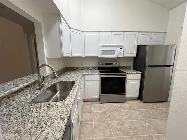 a kitchen with stainless steel appliances granite countertop a sink and a stove