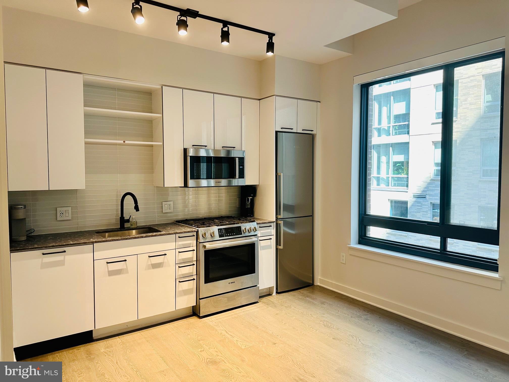 70 N Street Southeast, Unit N216 Washington, DC 20003 - Photo 3 of 20 a kitchen with stainless steel appliances a stove sink and refrigerator