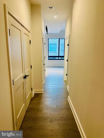 a view of a hallway with wooden floor