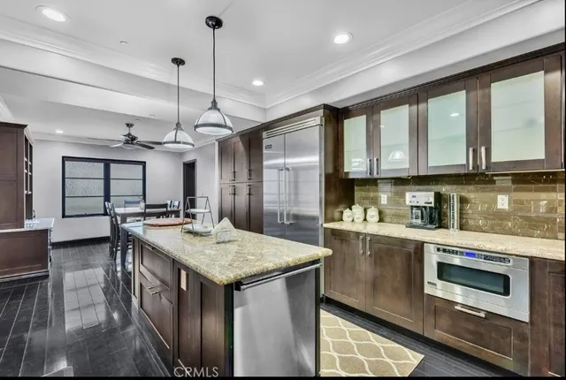 a kitchen with stainless steel appliances granite countertop a sink and cabinets with wooden floor