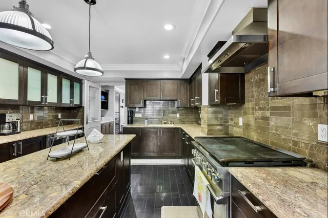 a kitchen with a sink a stove cabinets and a wooden floor