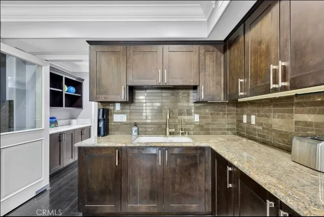 a kitchen with granite countertop a sink a stove and wooden cabinets