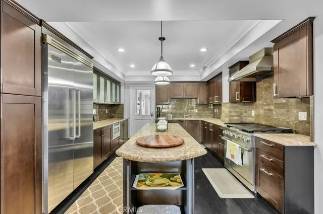 a kitchen with granite countertop stainless steel appliances a stove top oven a sink a counter space and cabinets
