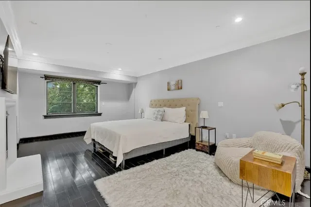 a spacious bedroom with a bed and a flat screen tv