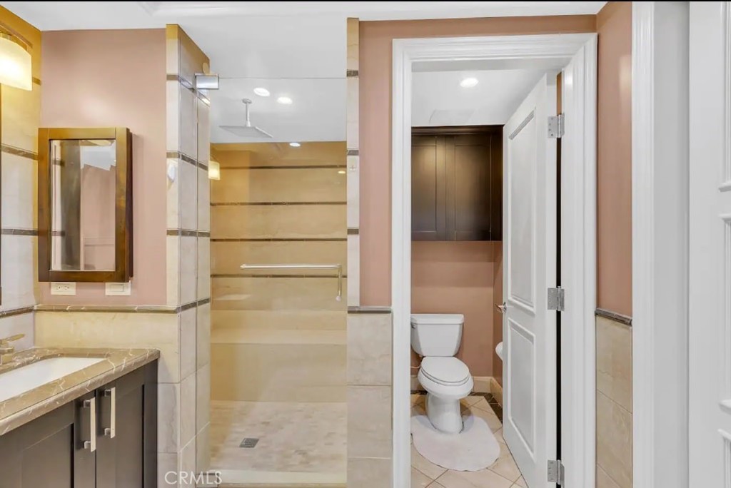 155 Cordova Street, Unit 203 Pasadena, CA 91105 - Photo 48 of 57 a bathroom with a granite countertop shower mirror and a toilet