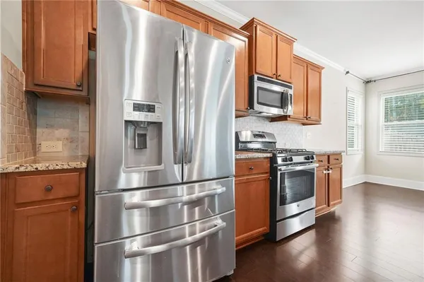a kitchen with stainless steel appliances granite countertop a refrigerator stove and microwave
