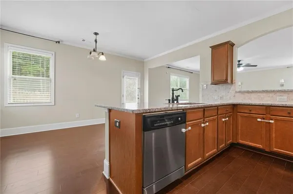 a kitchen with stainless steel appliances granite countertop a sink cabinets and wooden floor