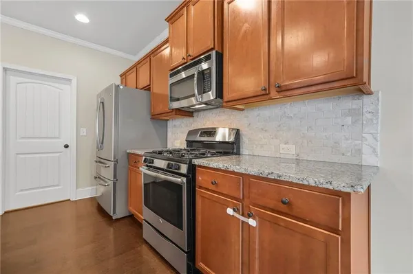 a kitchen with stainless steel appliances granite countertop a stove microwave and refrigerator