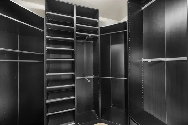 a view of walk in closet with empty racks