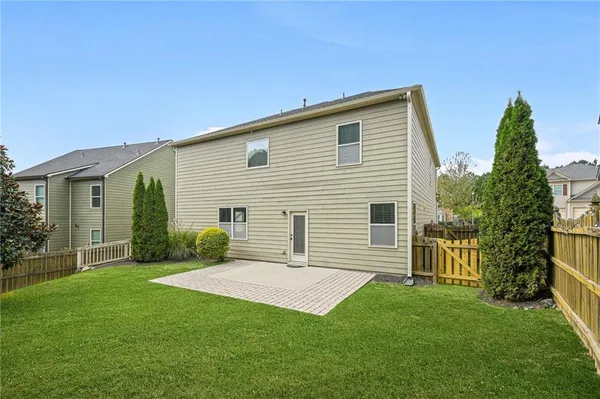a view of a house with backyard and a tree