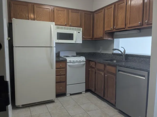a kitchen with stainless steel appliances granite countertop a refrigerator and a stove top oven