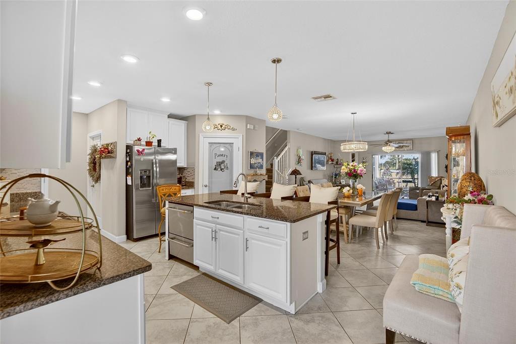 16909 April Plush Drive Wimauma, FL 33598 - Photo 6 of 89 a kitchen with stainless steel appliances kitchen island granite countertop a sink and a refrigerator