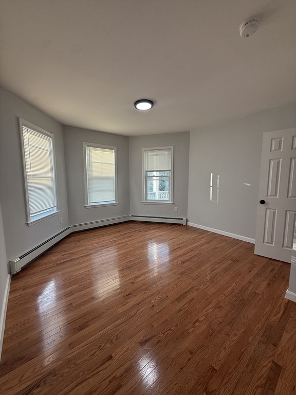 78 Hollis Street, Unit 2 Worcester, MA 01610 - Photo 5 of 8 an empty room with wooden floor and windows