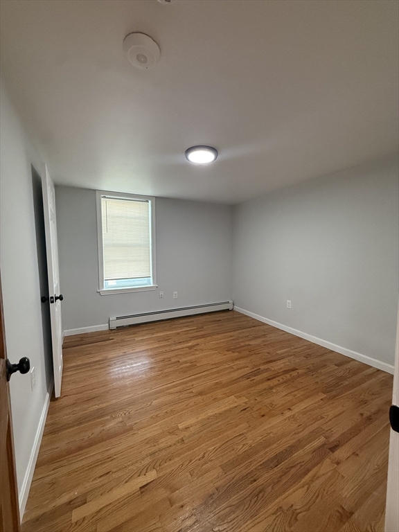 78 Hollis Street, Unit 2 Worcester, MA 01610 - Photo 6 of 8 an empty room with wooden floor and windows