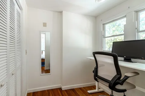 a front view of a house with a garden and trees