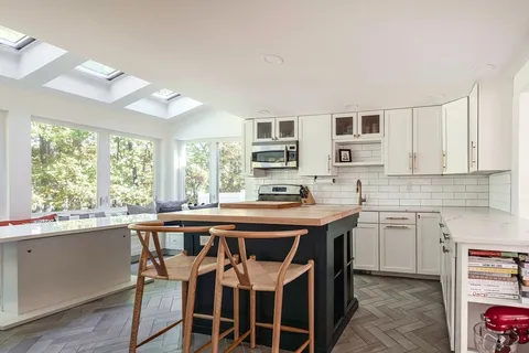 a kitchen with a table chairs sink and cabinets