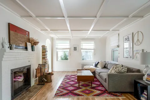 a living room with furniture fireplace and window