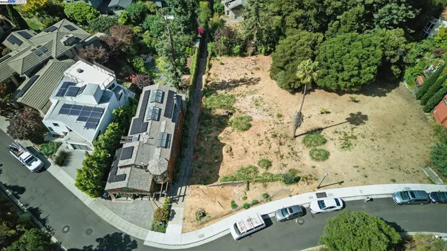an aerial view of a house with a yard and large trees