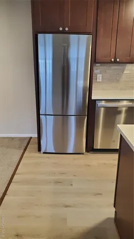 an empty room with wooden floor and a sink