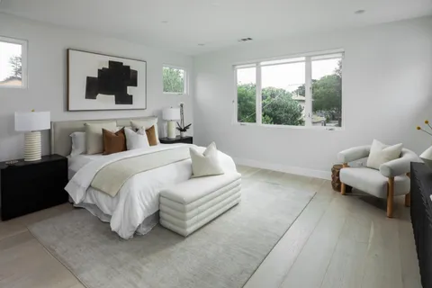 a bedroom with a bed a couch and a flat screen tv