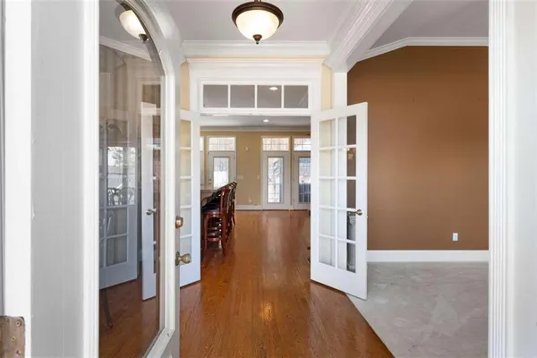 a view of a hallway with wooden floor and a living room