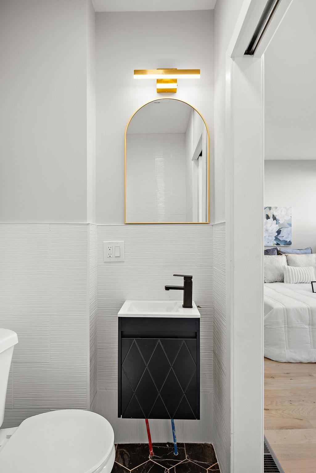 77 Boyd Avenue Jersey City, NJ 07304 - Photo 21 of 26 a bathroom with a toilet sink and mirror