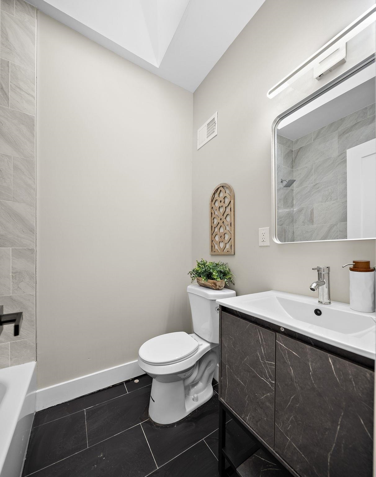 77 Boyd Avenue Jersey City, NJ 07304 - Photo 24 of 26 a bathroom with a toilet a sink and mirror