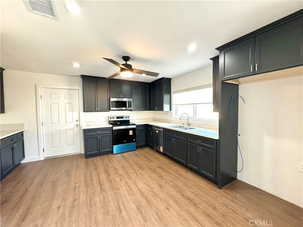 a kitchen with stainless steel appliances kitchen island granite countertop a stove a sink and a refrigerator