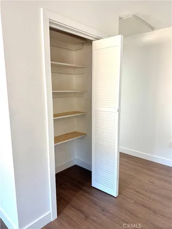 a view of walk in closet with wooden floor