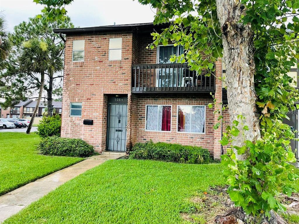 5084 Downing Street, Unit 2 Orlando, FL 32839 - Photo 1 of 7 a front view of a house with a garden and plants