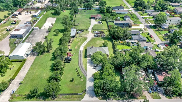 an aerial view of residential house with outdoor space and trees all around