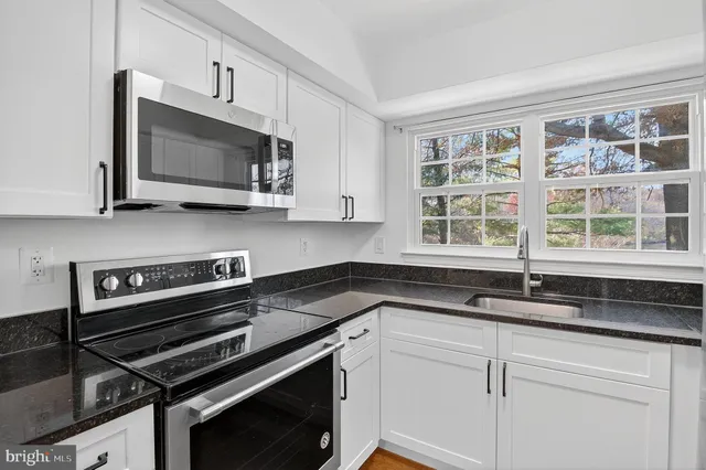 a kitchen with a sink stove and microwave