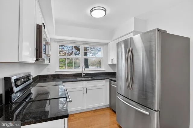 a kitchen with granite countertop a refrigerator and a sink