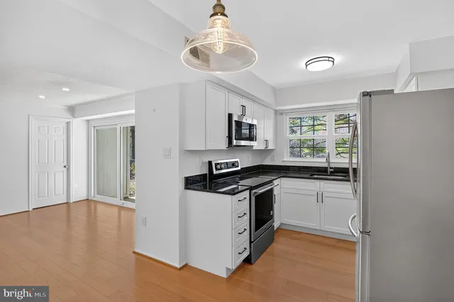 a kitchen with granite countertop a stove and a sink